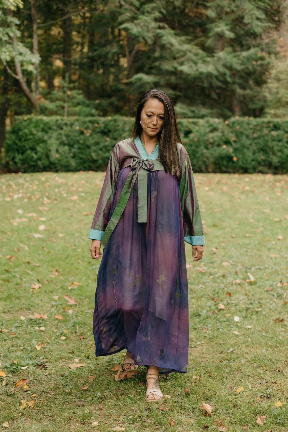 Woman wearing the 141 Adult/Child Korean Han-bok sewing pattern from Folkwear on The Fold Line. A wrap dress and jacket pattern made in silk, cotton, rayon, or polyester blend fabrics, featuring an above bust pleated band, wraps in back and ties in front,