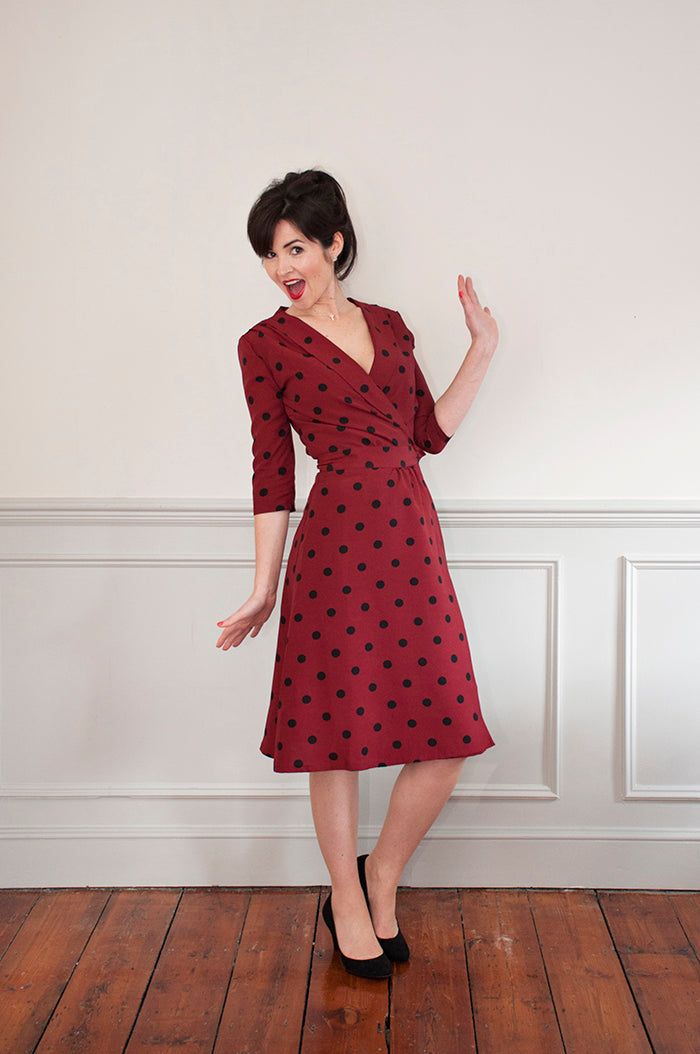 Woman wearing the 1940’s Wrap Dress sewing pattern from Sew Over It on The Fold Line. A dress pattern made in crepe, rayon, or cotton lawn fabrics, featuring a wrap front bodice, front collar, shoulder pleats, bodice gathers, waistband, hidden button clos