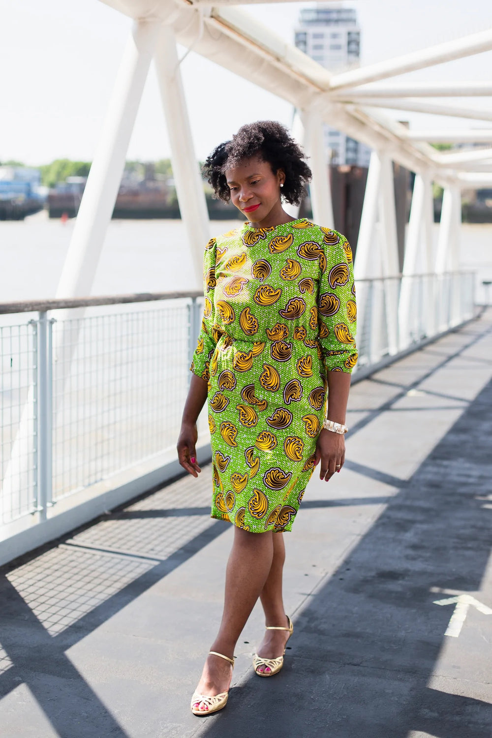 Woman wearing the Agatha Dress sewing pattern from Dovetailed on The Fold Line. A dress pattern made in wax print, lightweight and medium weight cottons, gauze, linen, silks, chambray, georgette and poplin fabrics, featuring in-seam pockets, high-low hem,