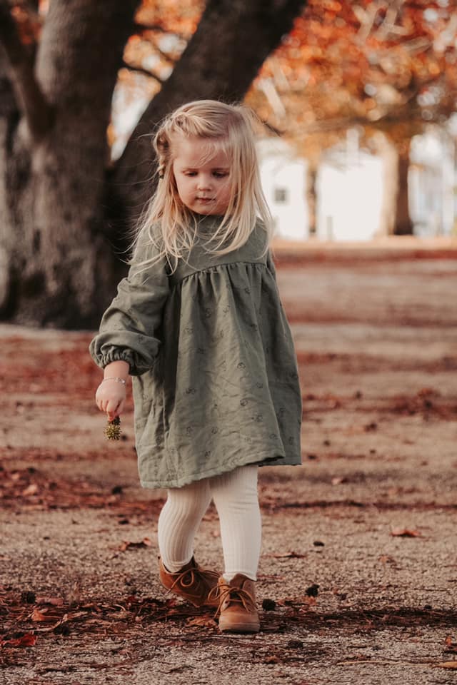 Child wearing the Bellbird Dress sewing pattern from Below the Kowhai on The Fold Line. A dungaree pattern made in cottons, voile, lawn, linen and linen blends, chambray, light denims, upholstery weight cottons, corduroy, velvet or drill fabrics, featurin