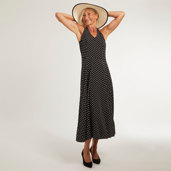 Woman wearing the Annie Dress sewing pattern from Coralie Bijasson on The Fold Line. A sleeveless dress pattern made in viscose crepe, poplin, or linen-viscose fabric, featuring a halter neck, open back, and midi length.