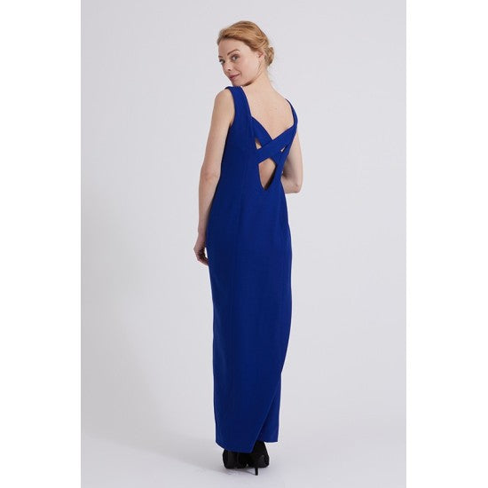 Woman wearing the Axelle Dress sewing pattern from Coralie Bijasson on The Fold Line. A sleeveless dress pattern made in cotton sateen, Milano, silk satin, brocade, or ottoman fabric, featuring a fitted silhouette, V-neckline, front slit, crossover back, and maxi length.
