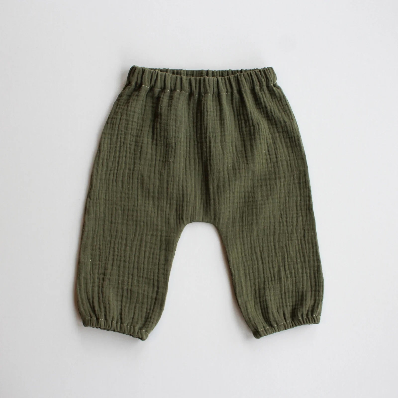 The Baby/Child August Pants sewing pattern from Oh Me Oh My Sewing on The Fold Line. A trousers pattern made in quilting cotton, washed linen, cotton lawn, or double gauze fabric, featuring an elastic waist and legholes and a gathered bubble silhouette.