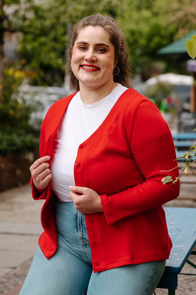 Woman wearing the Basic Cardigan sewing pattern from JULIANA MARTEJEVS on The Fold Line. A cardigan pattern made in knit fabric, featuring a shaped V-neck, long sleeves, and button front.