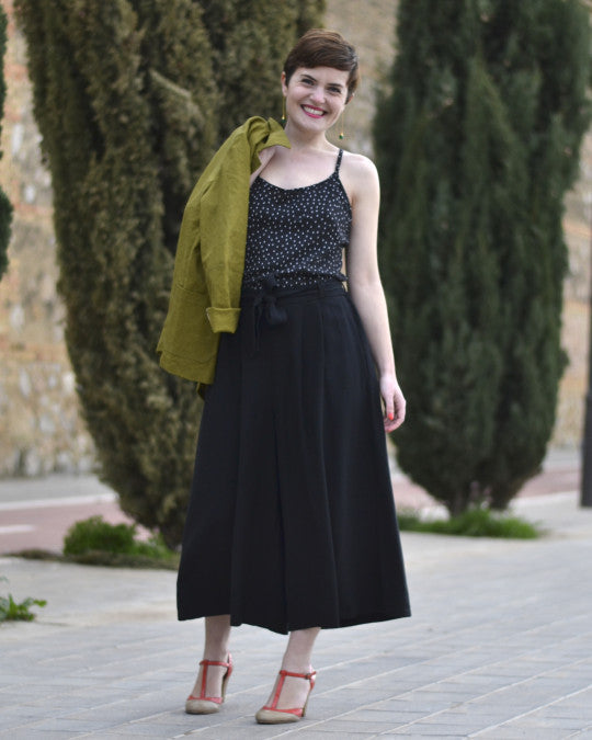 Woman wearing the Botanic Trousers sewing pattern from Pauline Alice on The Fold Line. A trousers pattern made in viscose, linen, cotton twill, crepe, light wool, or silk fabric, featuring a high waist with elastic in the back, removable belt, double-pleated front, in-seam pockets, wide leg, and cropped length.