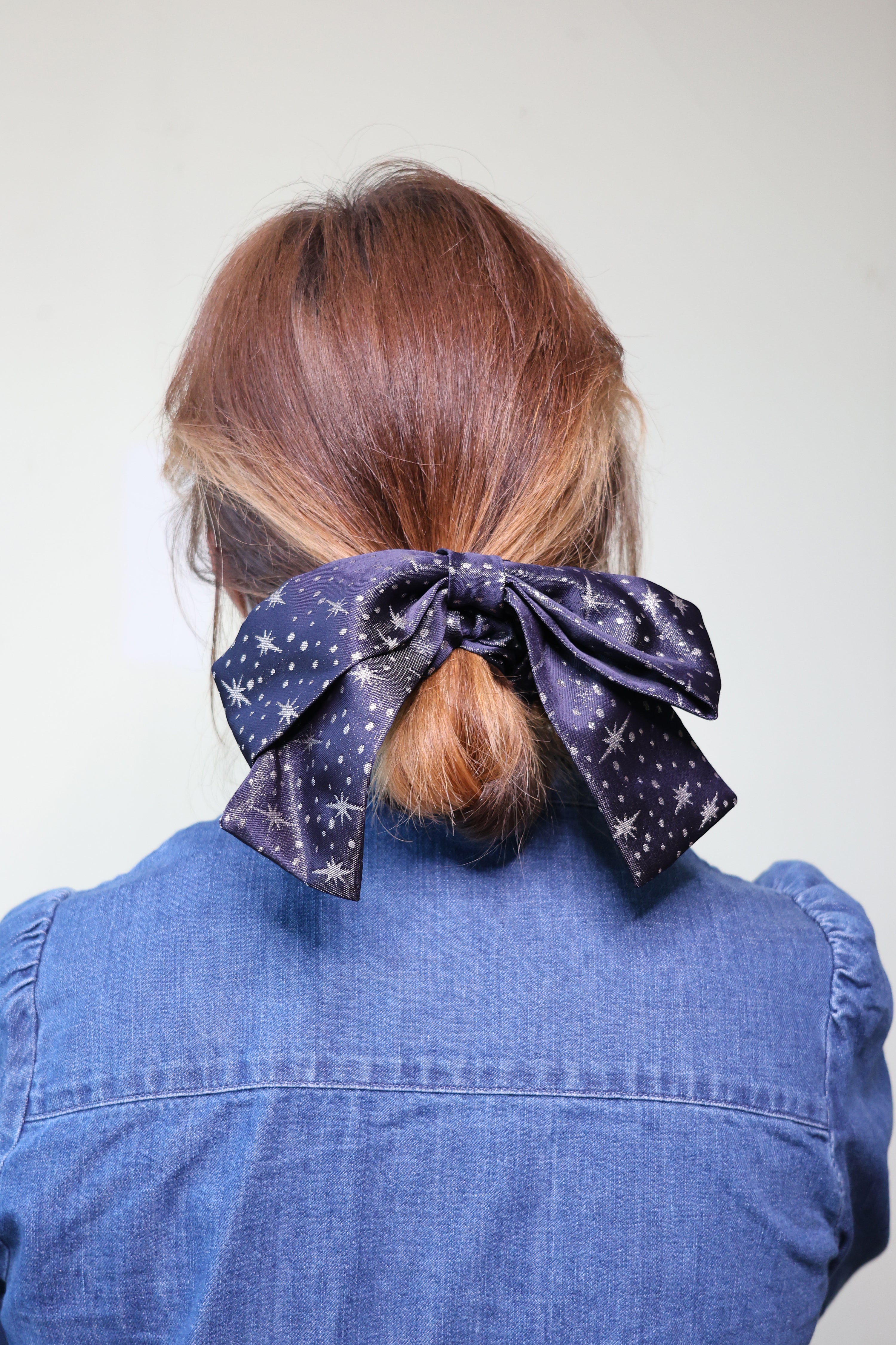 Woman wearing the Bow Scrunchie sewing pattern from Charlotte Emma Patterns on The Fold Line. A scrunchie pattern made in light to medium weight woven or knit fabric, featuring an optional bow which can be attached with a tab.