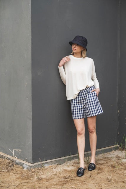 Woman wearing the Cara Jumper sewing pattern from Fibre Mood on The Fold Line. A jumper pattern made in knit fabric, featuring a round neckline, wide body, and long narrow sleeves.