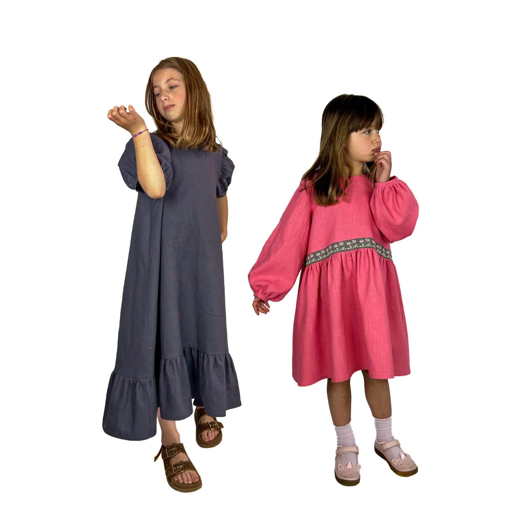 Girls wearing the Children's May Dress sewing pattern from Dhurata Davies Patterns on The Fold Line. A dress pattern made in linen, cotton chambray, poplin, lawn, double gauze, or needle cord fabric, featuring an A-line silhouette, high-low hem, gathered skirt or ruffled hem, and short puff sleeves or long bishop sleeves.