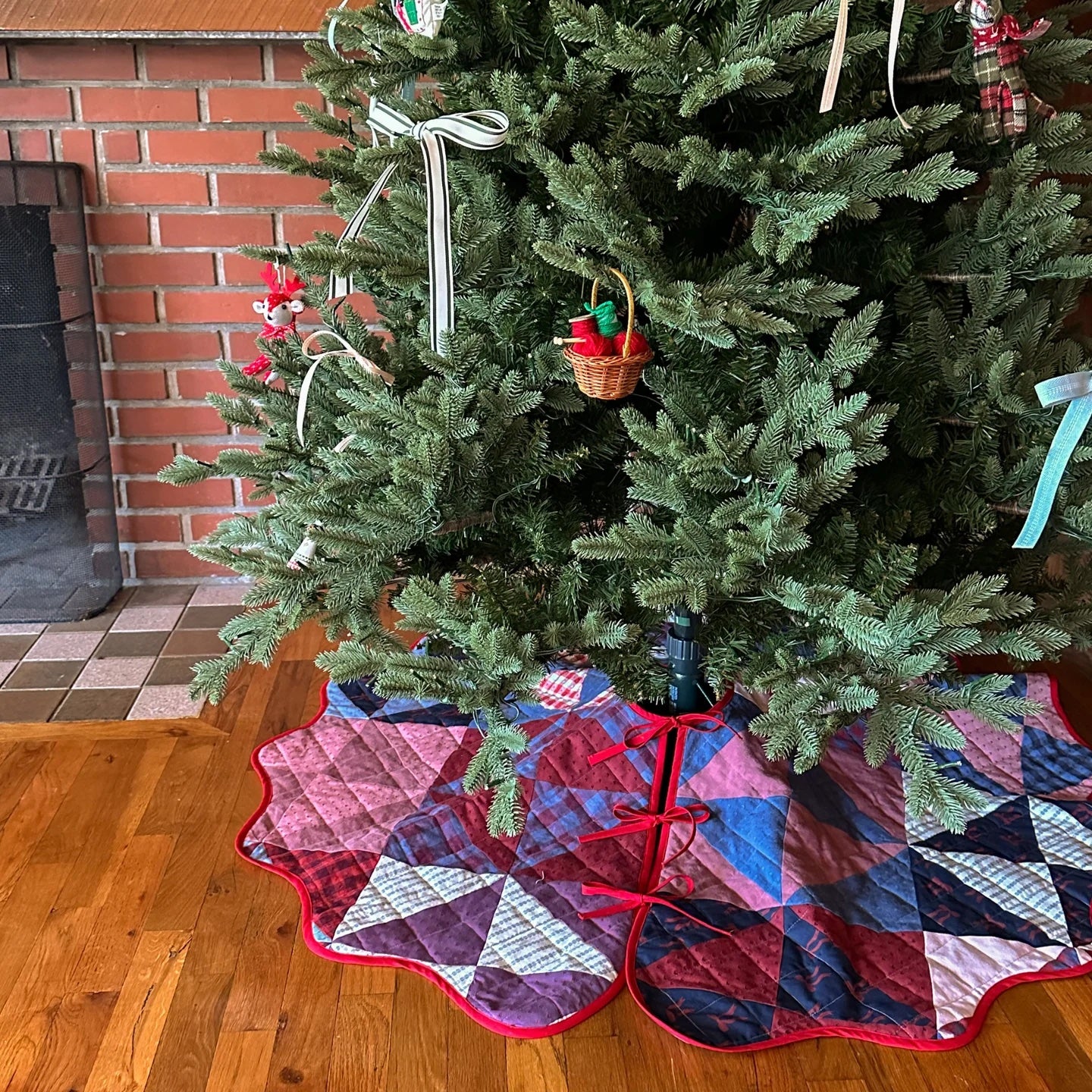 The Connie Tree Skirt sewing pattern from Syd Graham Patterns on The Fold Line. A reversible tree skirt pattern made in quilting cotton, flannel, or pre-quilted fabric, featuring a bound scalloped edge and tie closures.