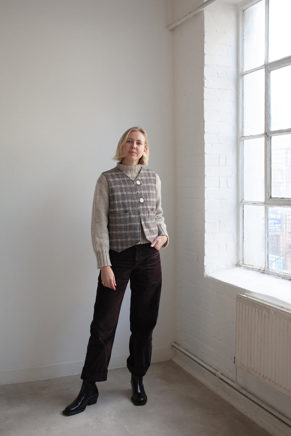 Woman wearing the Devon Waistcoat sewing pattern from the Modern Sewing Co. on The Fold Line. A lined waistcoat pattern made in wool, twill, denim, canvas, quilting, or heavy linen fabric, featuring a classic silhouette with feminine shaping, two buttons, and patch pockets.