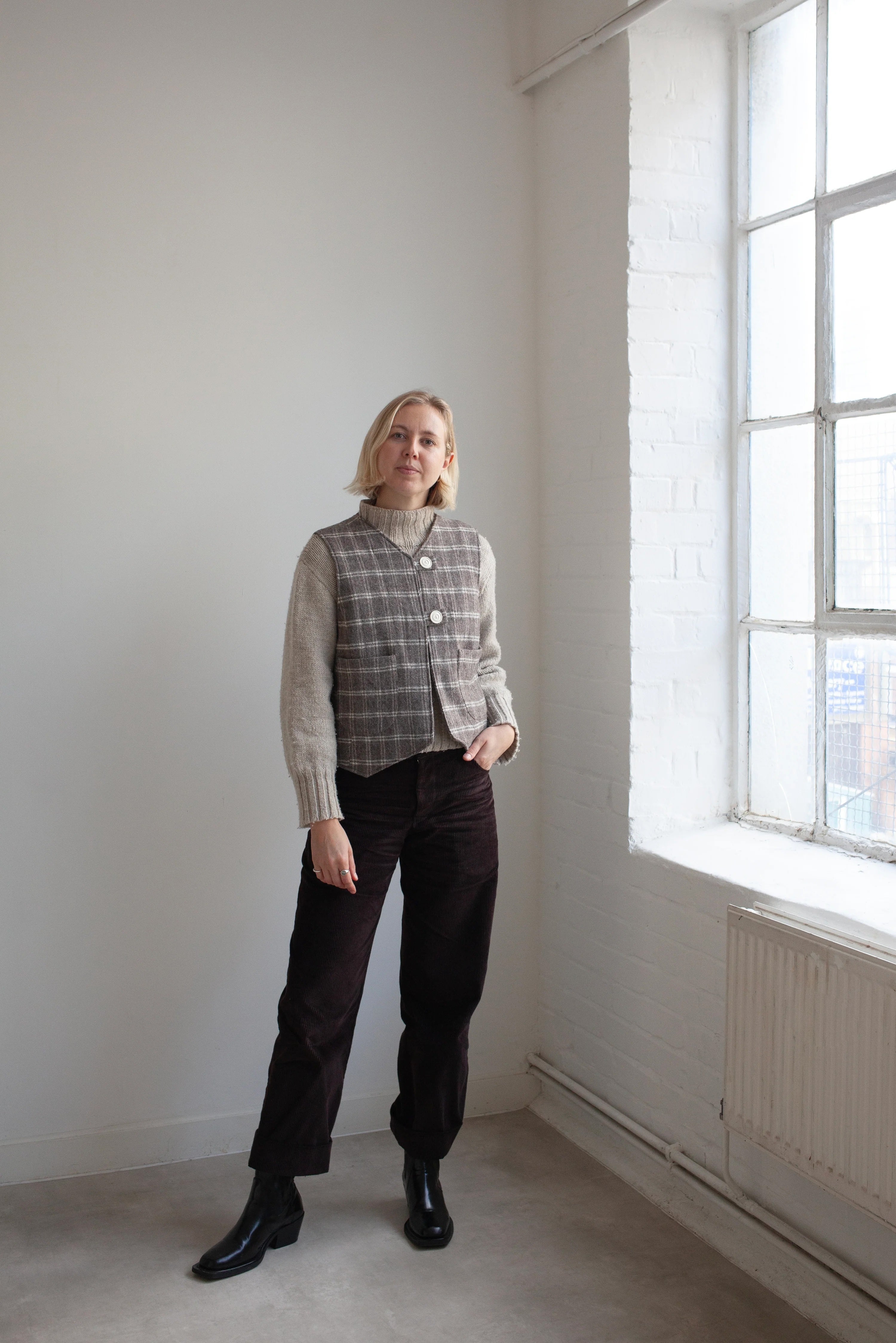 Woman wearing the Devon Waistcoat sewing pattern from the Modern Sewing Co. on The Fold Line. A lined waistcoat pattern made in wool, twill, denim, canvas, quilting, or heavy linen fabric, featuring a classic silhouette with feminine shaping, two buttons, and patch pockets.