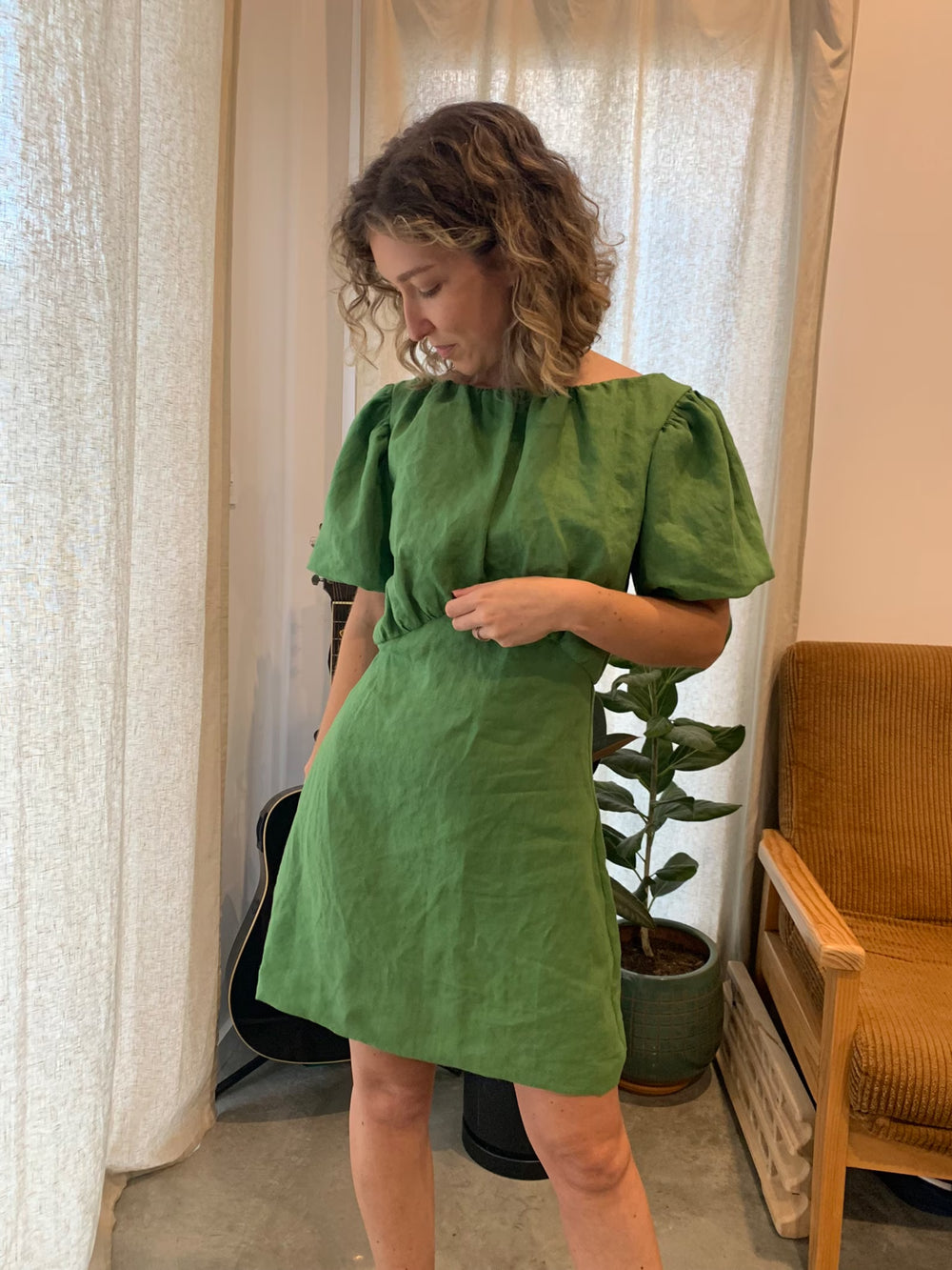 Woman wearing the Fleur Dress sewing pattern from Elle Stitch on The Fold Line. A dress pattern made in linen, cotton, or mid to heavy weight silk fabric, featuring a gathered bodice, short puff sleeves, and a mini length.