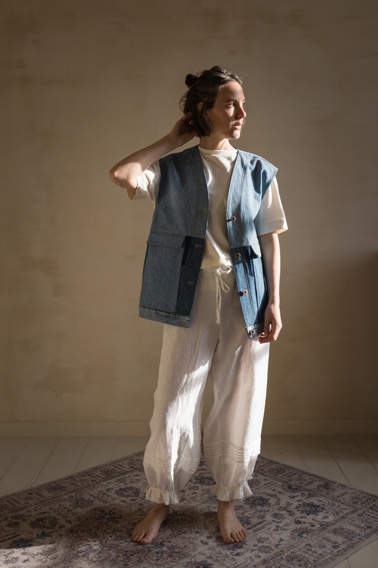 Woman wearing the Hendrix Sleeveless Jacket sewing pattern from Ready to Sew on The Fold Line. A sleeveless jacket or vest pattern made in denim, cotton gabardine, cotton twill or canvas, moleskin, heavyweight flannel, wool coating, corduroy, heavyweight hemp or linen, or quilted cotton fabric, featuring a loose fit, wide armholes, button front, and patch pockets.