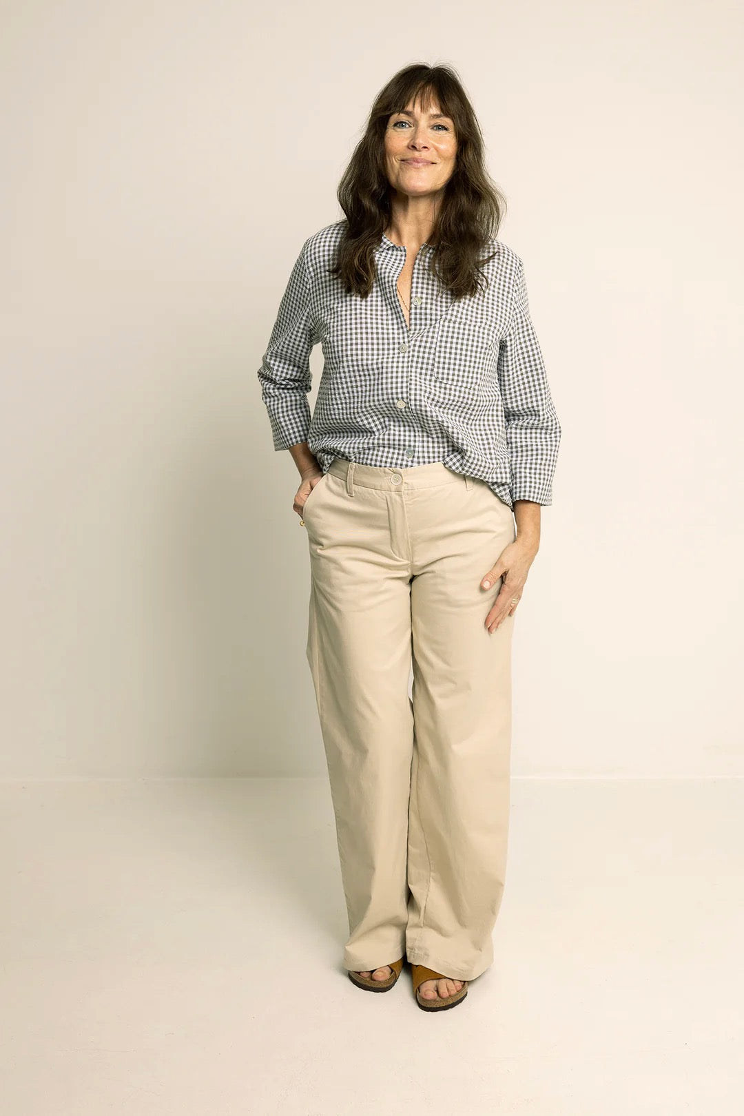Woman wearing the Hepburn Pants sewing pattern from Wardrobe by Me on The Fold Line. A trousers pattern made in cotton, linen, canvas, or denim fabric, featuring a fly front zip, waistband with belt loops, side pockets, and back welt pockets.