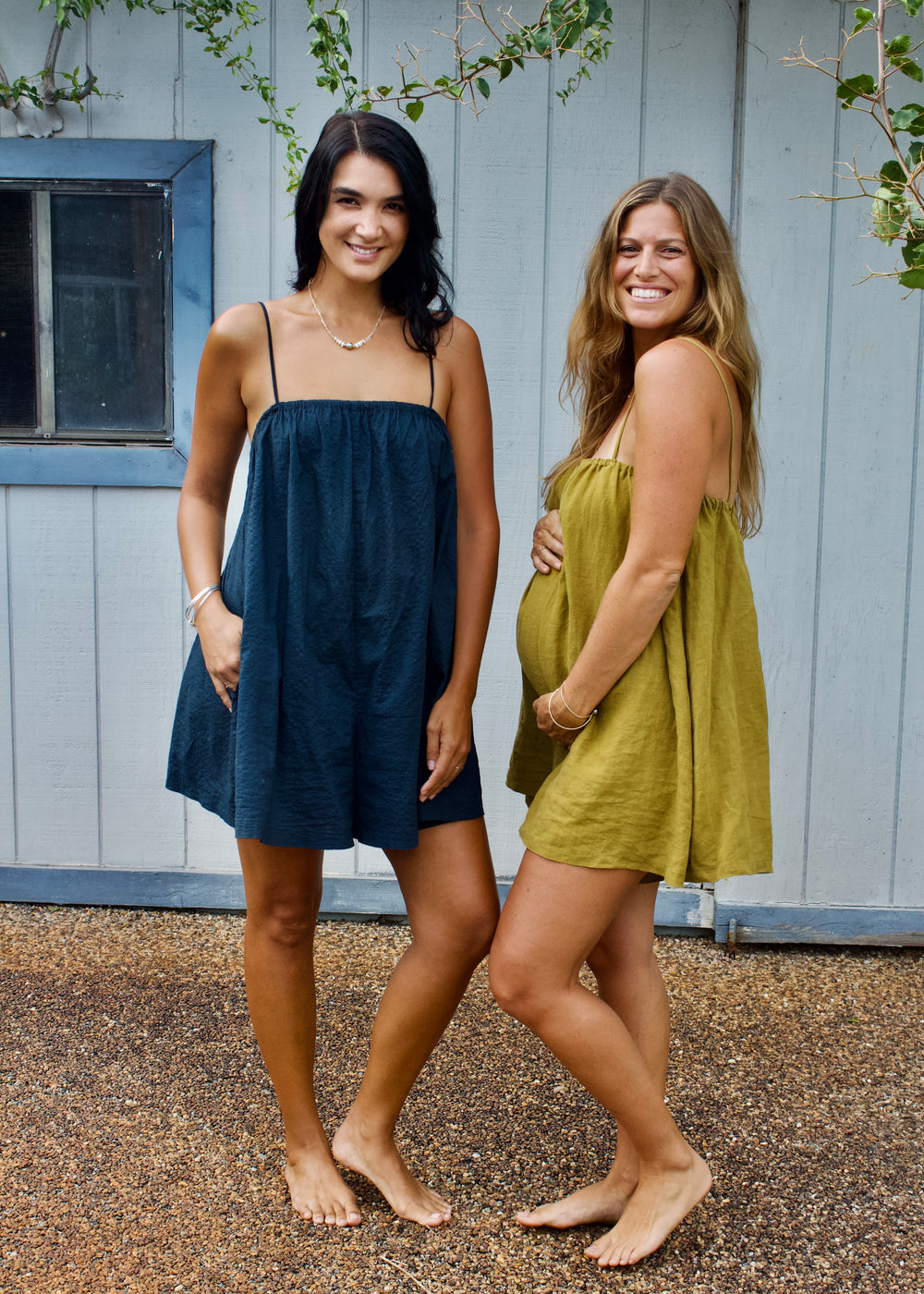 Women wearing the Humla Romper sewing pattern from Paradise Patterns on The Fold Line. A romper pattern made in linen, seersucker, cotton poplin, rayon, or tencel fabric, featuring a relaxed fit, thin straps, built-in bralette, and pockets.