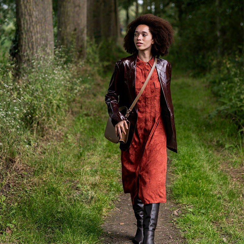 Woman wearing the Ildri Dress sewing pattern from Fibre Mood on The Fold Line. A shirt dress pattern made in viscose (crepe), lyocell, silk, poplin, chambray, or fine or baby wale corduroy fabric, featuring a relaxed fit, shirt collar, concealed button placket, chest pockets, and loose A-line sleeves.