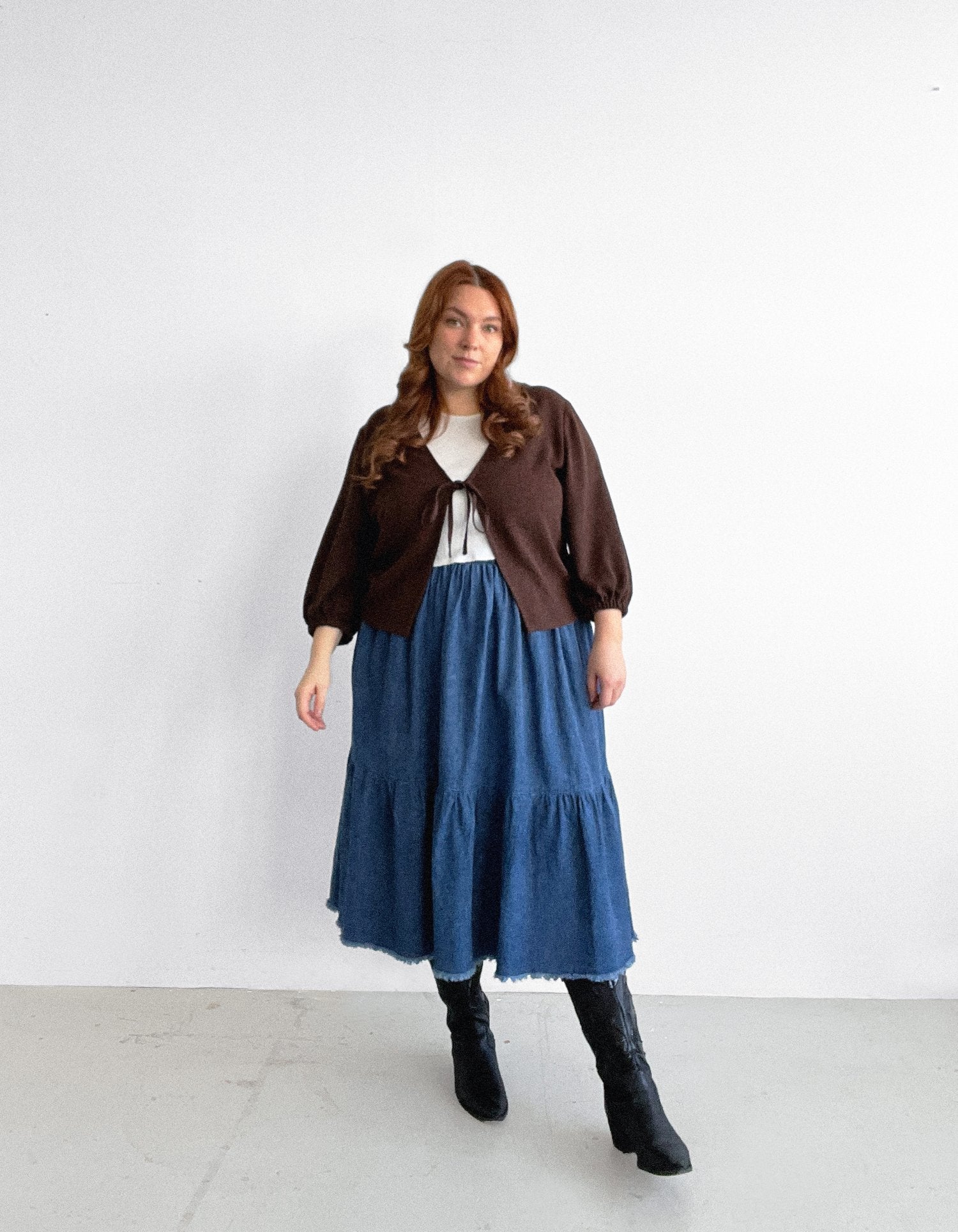 Woman wearing the Layover Cardigan sewing pattern from Les Perlines on The Fold Line. A cardigan pattern made in rayon, viscose, cotton, linen, or tencel twill fabric, featuring a V-neck, tie front, and long sleeves with elasticated cuffs.