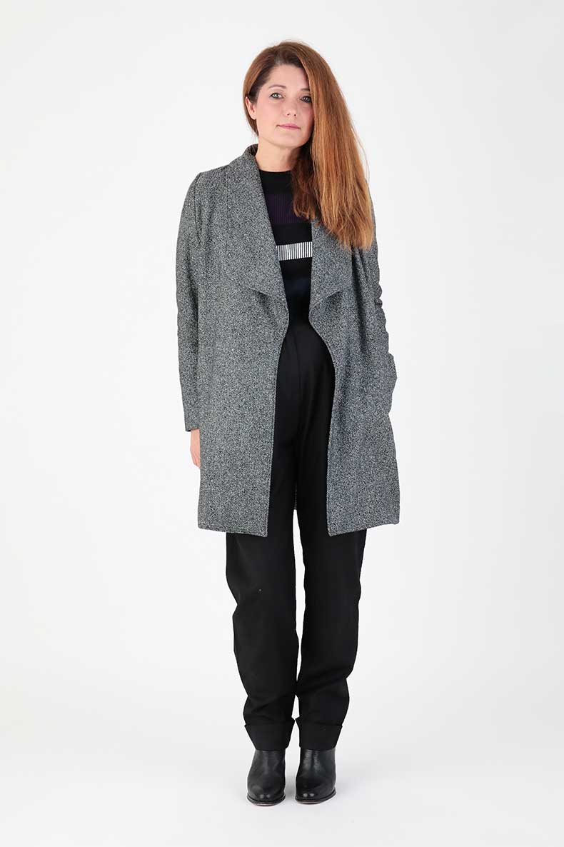 Woman wearing the Lenja Coat sewing pattern from Schnittchen Patterns on The Fold Line. An unlined coat pattern made in wool, boiled wool, or knit fabric, featuring a slight A-line silhouette, collar with wide cut lapels, narrow two-piece sleeves, and pockets.