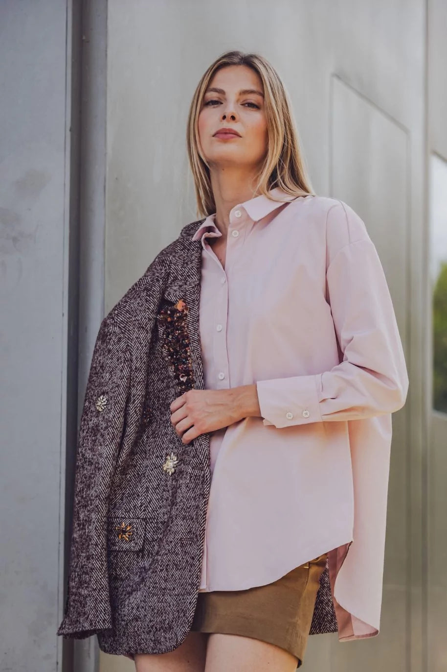 Woman wearing the Lee Shirt sewing pattern from Fibre Mood on The Fold Line. A shirt pattern made in poplin, modal, lyocell, linen, seersucker, chambray, woven viscose, fine corduroy, or broderie anglaise fabric, featuring a collar, button front, long sleeves with mitred cuffs, and a back slit.