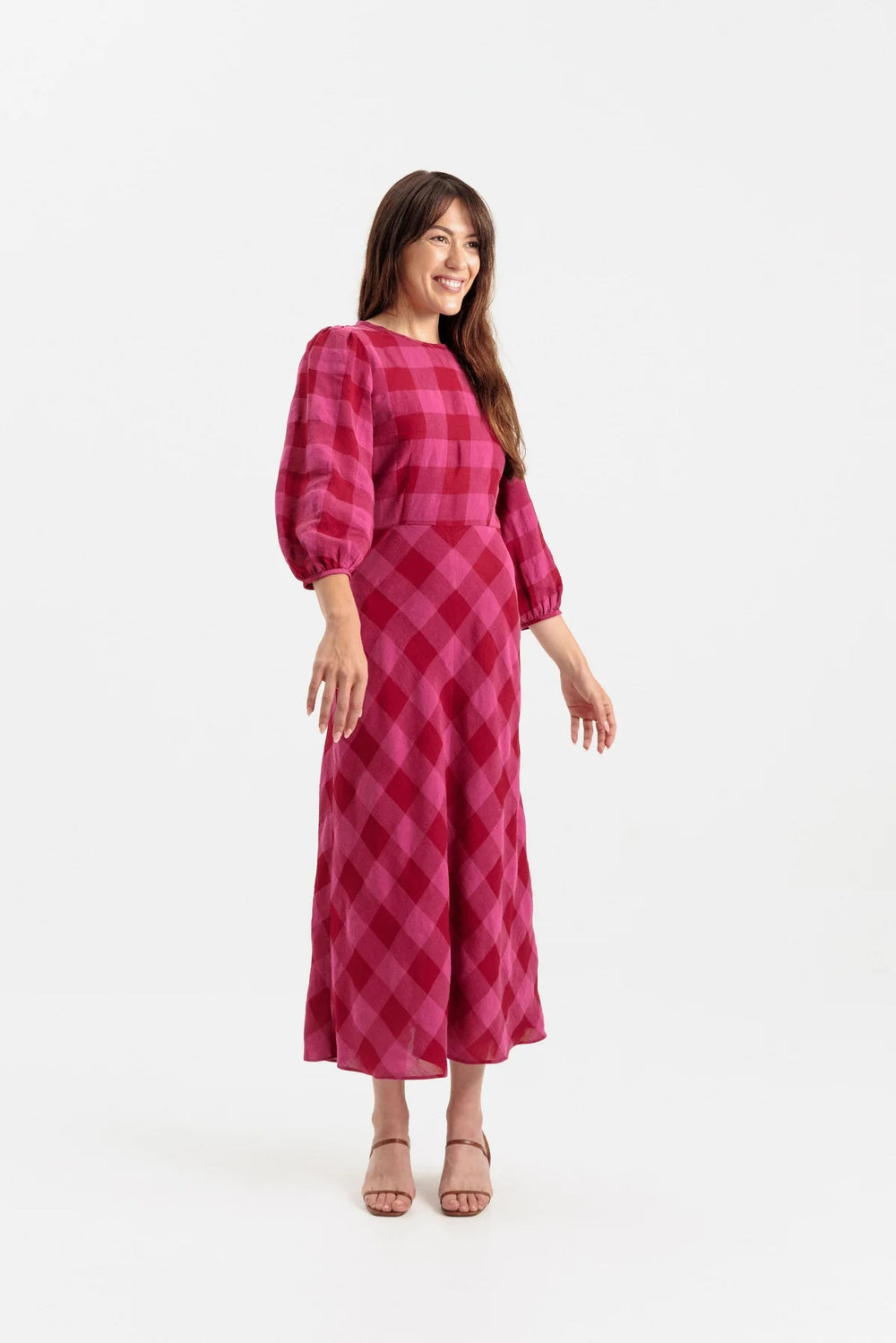 Woman wearing the Lulee Dress sewing pattern from Papercut Patterns on The Fold Line. A dress pattern made in cotton, linen, silk, or rayon fabric, featuring a round neck, darted bodice, long gathered sleeve, and hip skimming bias cut skirt.