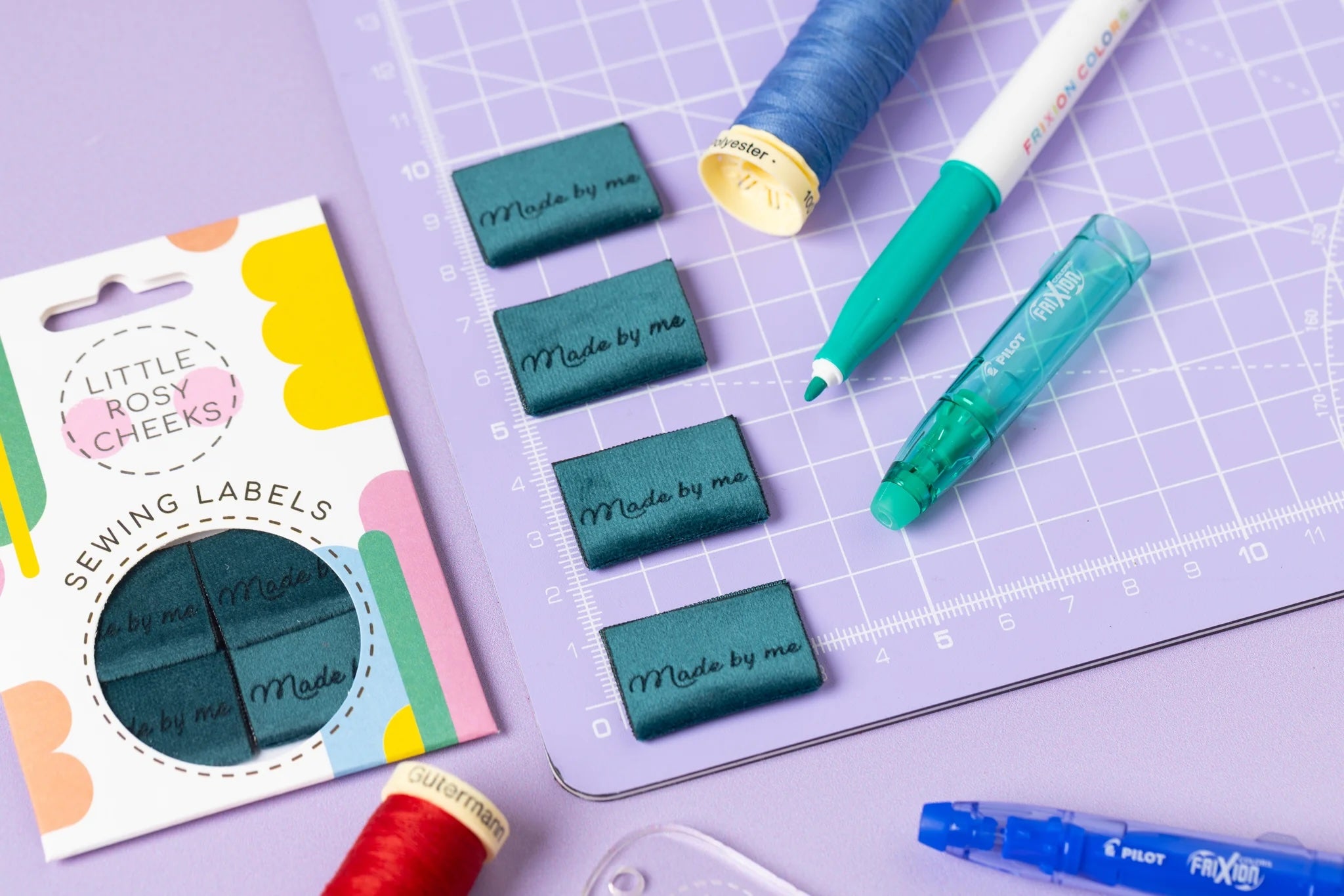 The 'Made by Me Velvet' woven labels from Little Rosy Cheeks on The Fold Line. The pack includes 4 labels featuring laser engraved text on a teal velvet background, ready to be sewn into your handmade clothes.