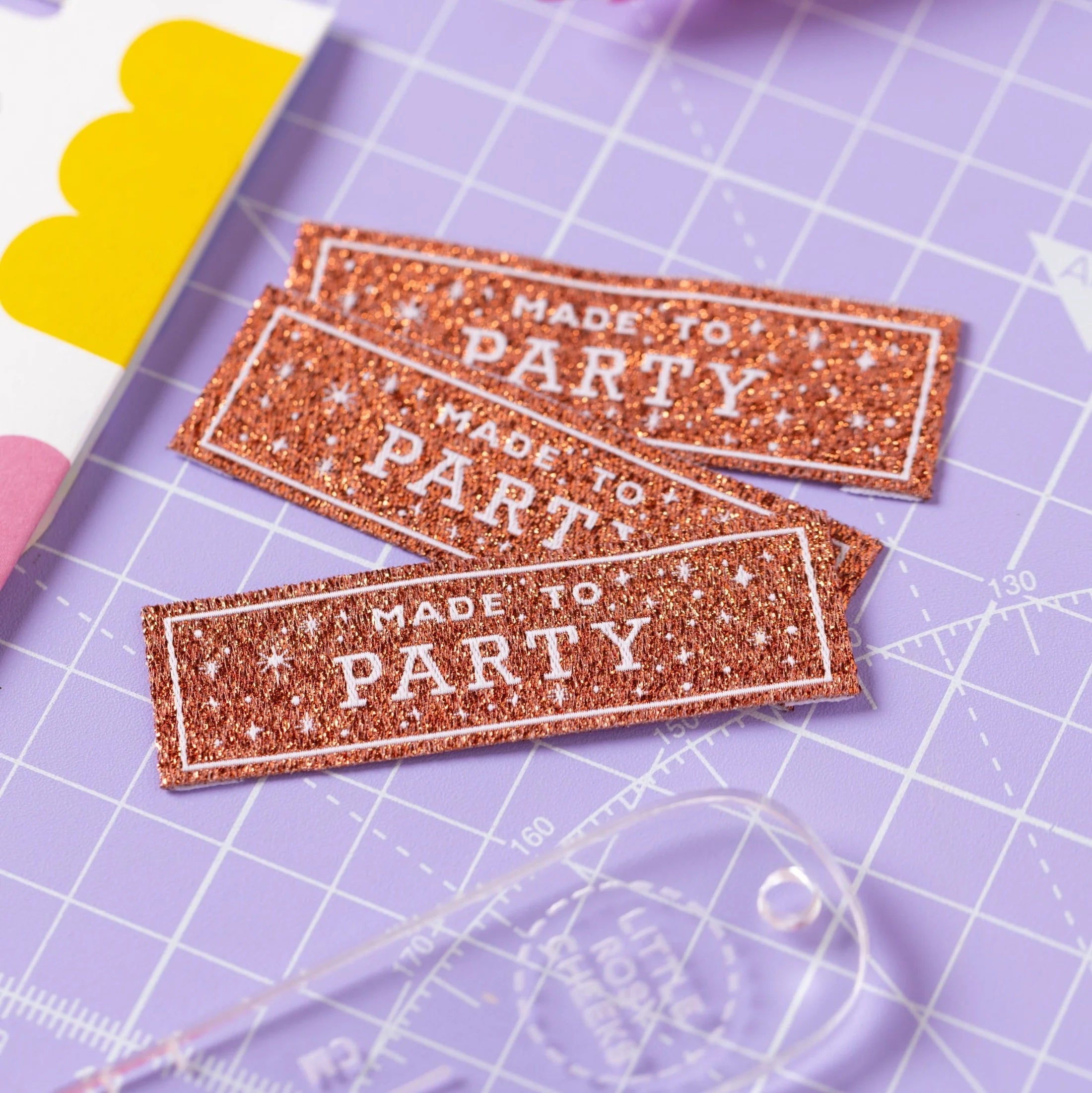 The 'Made to Party' woven labels from Little Rosy Cheeks on The Fold Line. The pack includes 6 sparkly rose gold woven labels ready to be sewn into your handmade clothes.