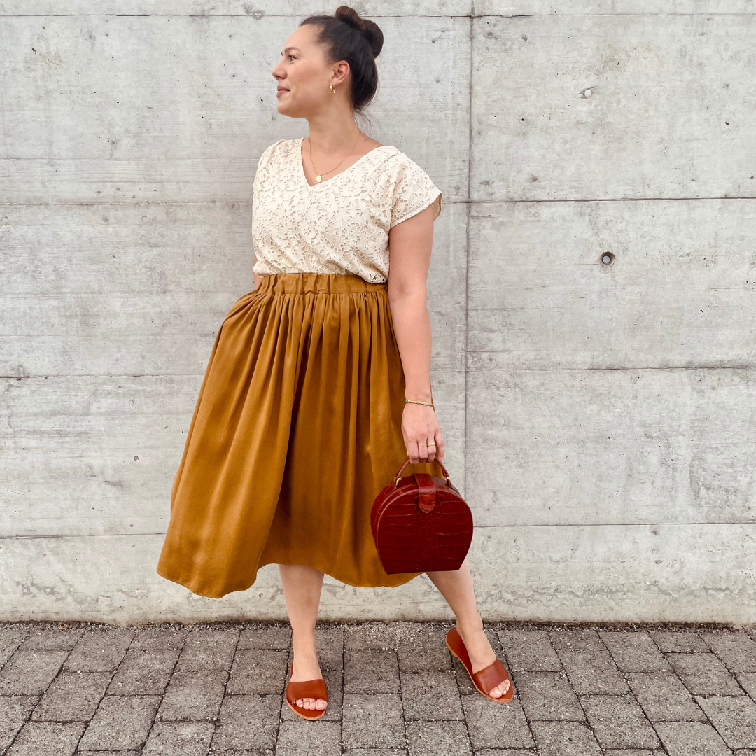 Woman wearing the Martha Skirt sewing pattern from Sew.lala Patterns on The Fold Line. A skirt pattern made in linen, poplin, cotton, viscose, or silk fabric, featuring an elastic waist, side pockets, and midi length.