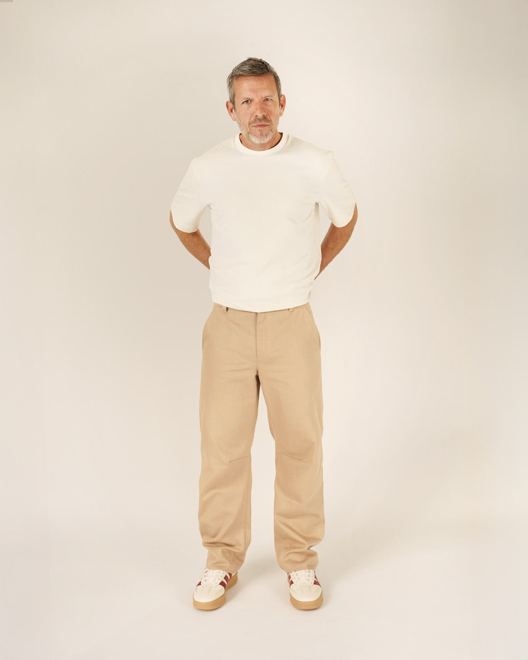 Man wearing the Men's Barrel Chino Pants sewing pattern from Wardrobe by Me on The Fold Line. A trousers pattern made in bottom weight woven cotton, linen, canvas, or denim fabric, featuring a relaxed barrel leg, waistband with belt loops, fly front zipper, side pockets, and back welt pockets.