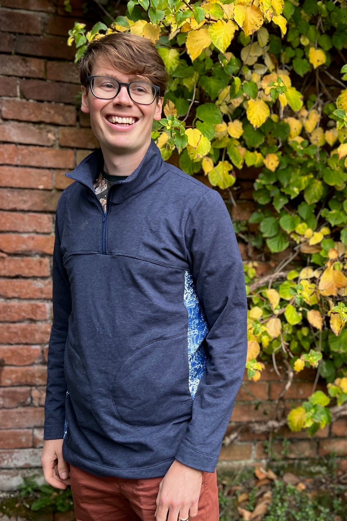 Man wearing the Men’s Quokka Quarter Zip Top sewing pattern from Waves & Wild on The Fold Line. A top pattern made in sweatshirt fleece or alpine fleece fabric, featuring a relaxed fit, high neck with a zip, long sleeves, and pockets.