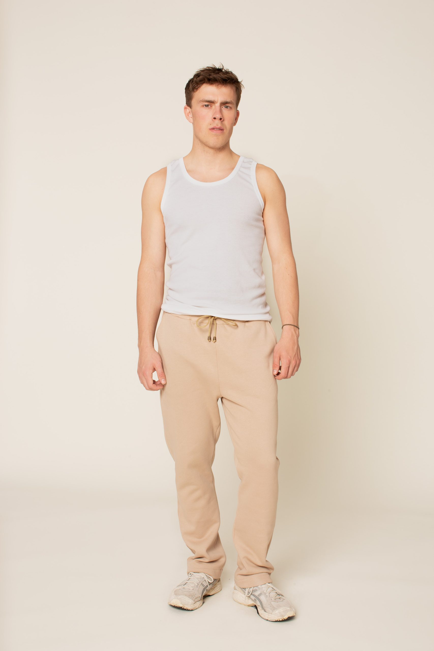 Man wearing the Men's Rebel Sweatpants sewing pattern from Wardrobe by Me on The Fold Line. A sweatpants pattern made in French terry fabric, featuring a relaxed fit, rib waistband, deep pockets, back pocket and drawstring.