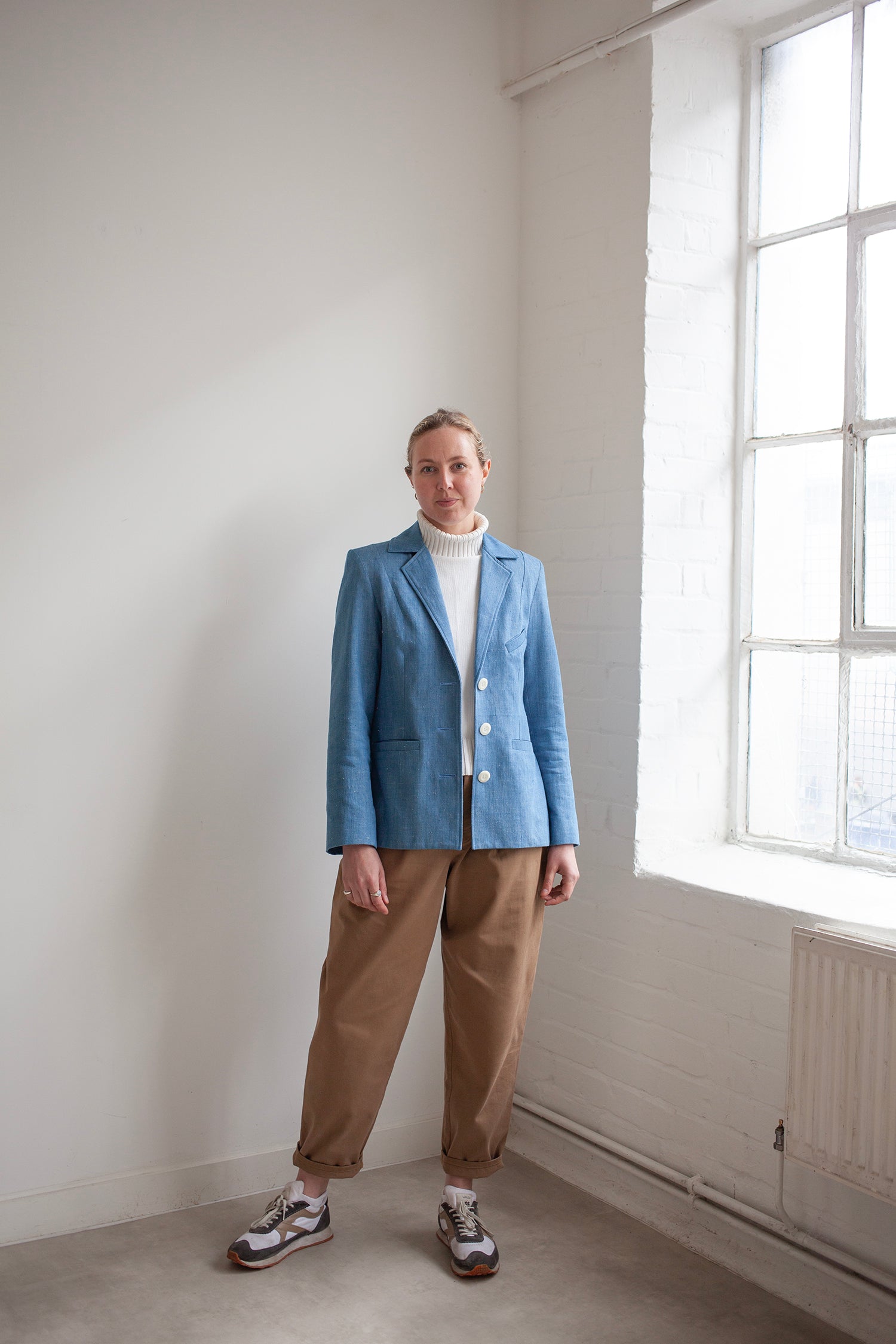 Woman wearing the Naomi Blazer sewing pattern from the Modern Sewing Co on The Fold Line. A fully lined blazer pattern made in wool, velvet, denim, gabardine, twill, thick linen weave, or raw silk fabric, featuring an hourglass shape, welt pockets, two-piece sleeve, and back vent.