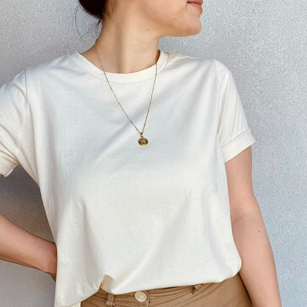 Woman wearing the Nora Tee sewing pattern from Sew.lala Patterns on The Fold Line. A T-shirt pattern made in cotton jersey, viscose jersey, ponte knit, or lightweight linen knit fabric, featuring a relaxed fit, round neck with ribbing, and short sleeves.
