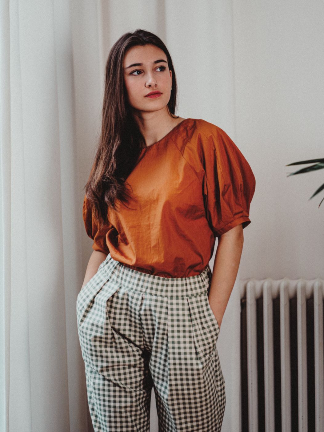 Woman wearing the Odell Top sewing pattern from Notches on The Fold Line. A top pattern made in cotton, linen, canvas, denim, or baby cord fabric, featuring a round neckline and statement puff sleeves.