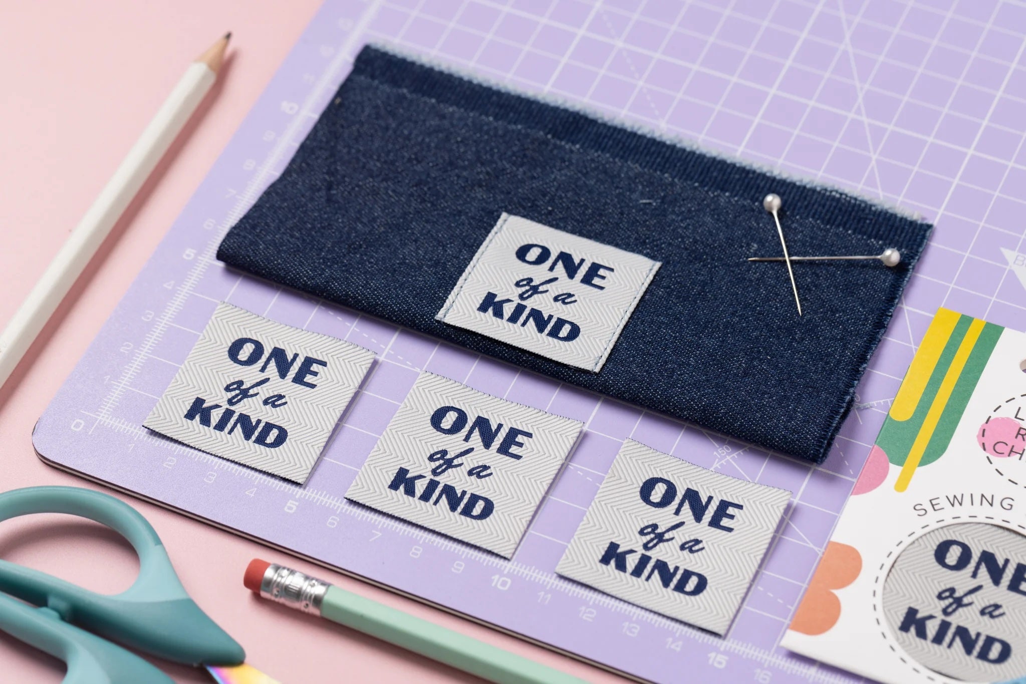 The 'One of a Kind' woven labels from Little Rosy Cheeks on The Fold Line. The pack includes 4 labels featuring a ribbed chevron texture and navy text on a stone background, ready to be sewn into your handmade clothes.