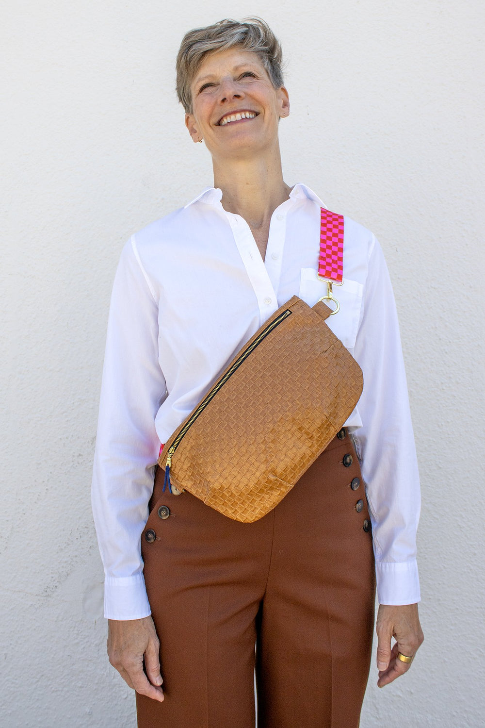 Woman wearing the Paquette Bag sewing pattern from Christine Haynes on The Fold Line. A cross body bag pattern made in cotton, linen, denim, wool, corduroy, canvas, upholstery, leather, or vinyl fabric, featuring a full lining and zipper closure.