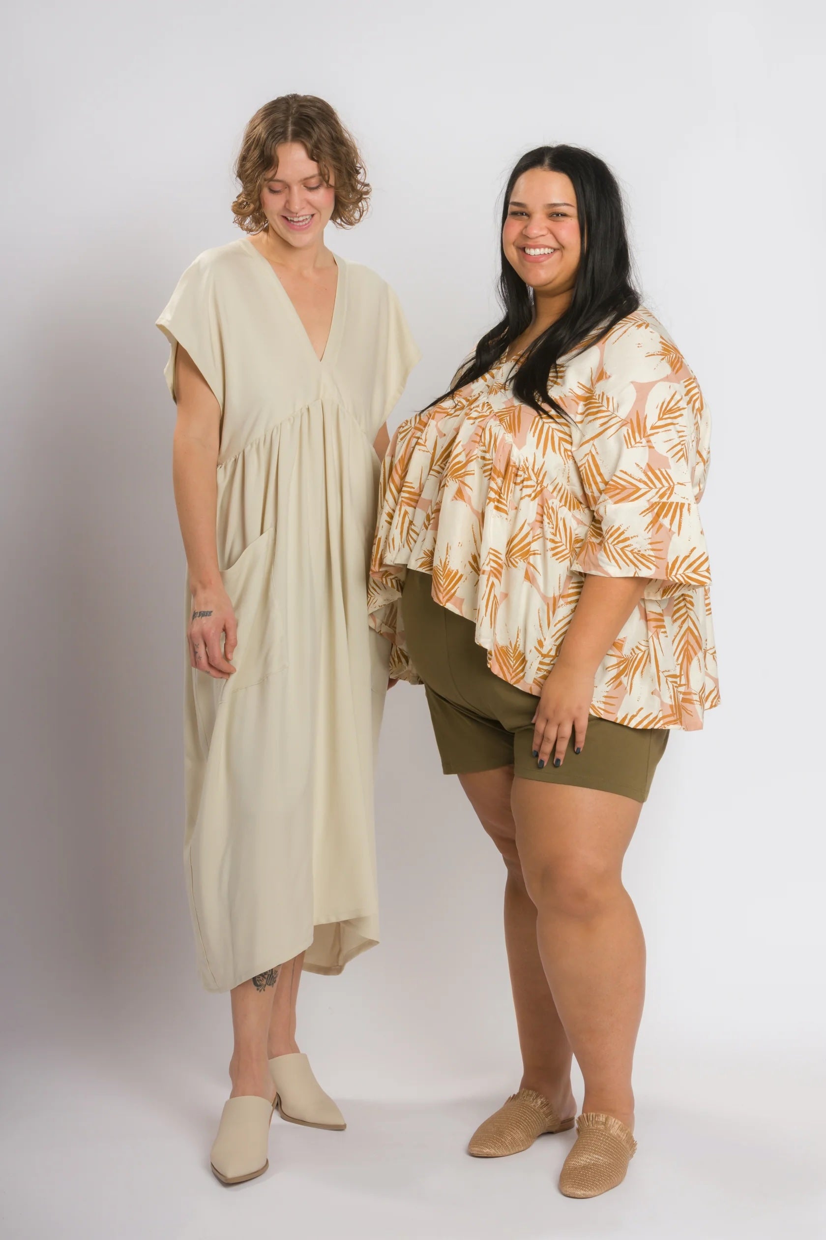 Women wearing the Parasol Dress and Top sewing pattern from Cris Wood Sews on The Fold Line. A dress and top pattern made in cotton, linen, double gauze, rayon, silk, or viscose fabric, featuring front and back v-necklines and a back neck tie, and dropped shoulders, a gathered skirt, patch pockets, and midi length for the dress, and elbow length sleeves and a gathered panel for the top.