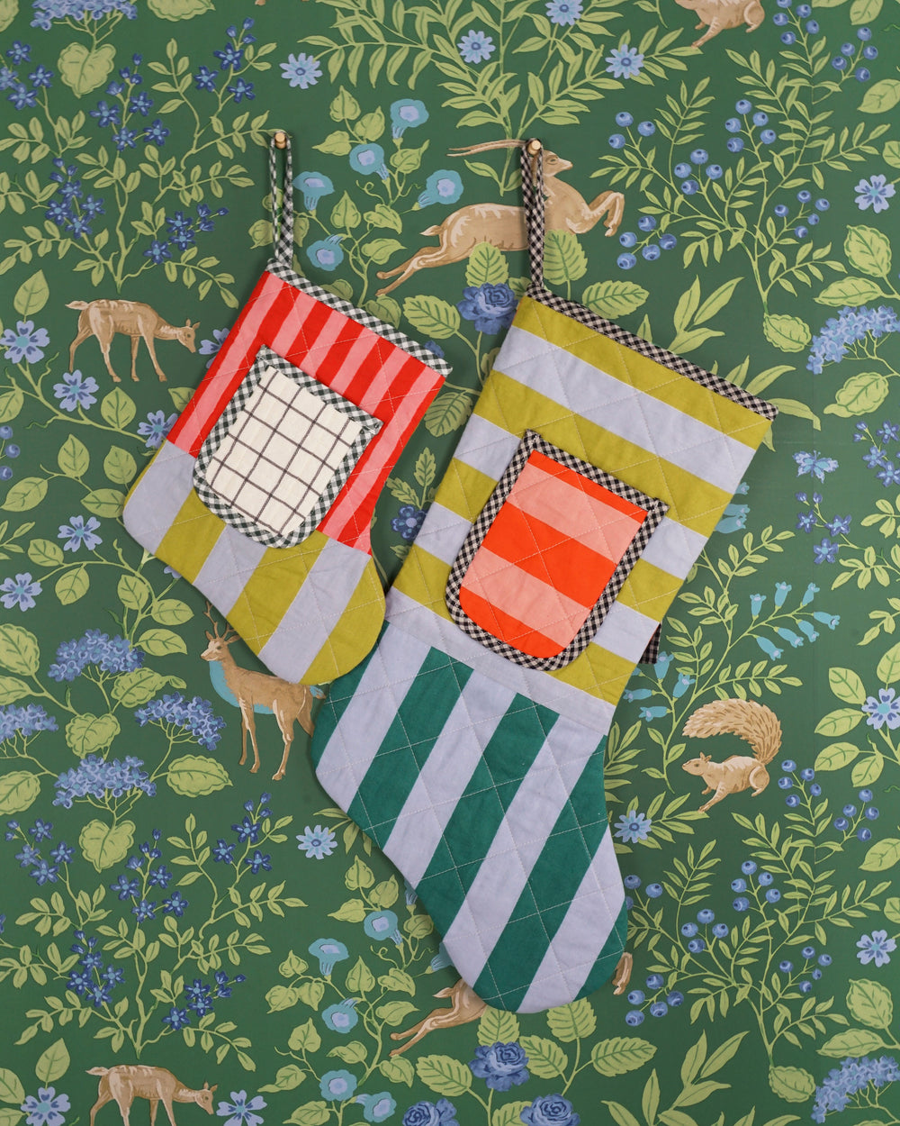 The Quilted Pocket Stocking sewing pattern from Matchy Matchy Sewing Club on The Fold Line. A Christmas stocking pattern made in cotton, flannel, or linen fabric, featuring two sizes, a front pocket, and hanging loop.