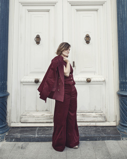 Woman wearing the Reig Trousers sewing pattern from Pauline Alice on The Fold Line. A trousers pattern made in suiting woollens and cottons, linen, cotton twill, wool crepe, or corduroy fabric, featuring a high waist, fly front zipper, waistband with a D-ring and button fastening, wide leg, and in-seam pockets.