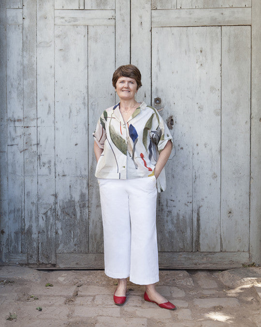 Woman wearing the Romero Trousers sewing pattern from Pauline Alice on The Fold Line. A sailor trousers pattern made in cotton canvas, linen, gabardine, twill, denim, wool, or corduroy fabric, featuring a high waist, button closure, pockets, wide leg, and cropped ankle length.