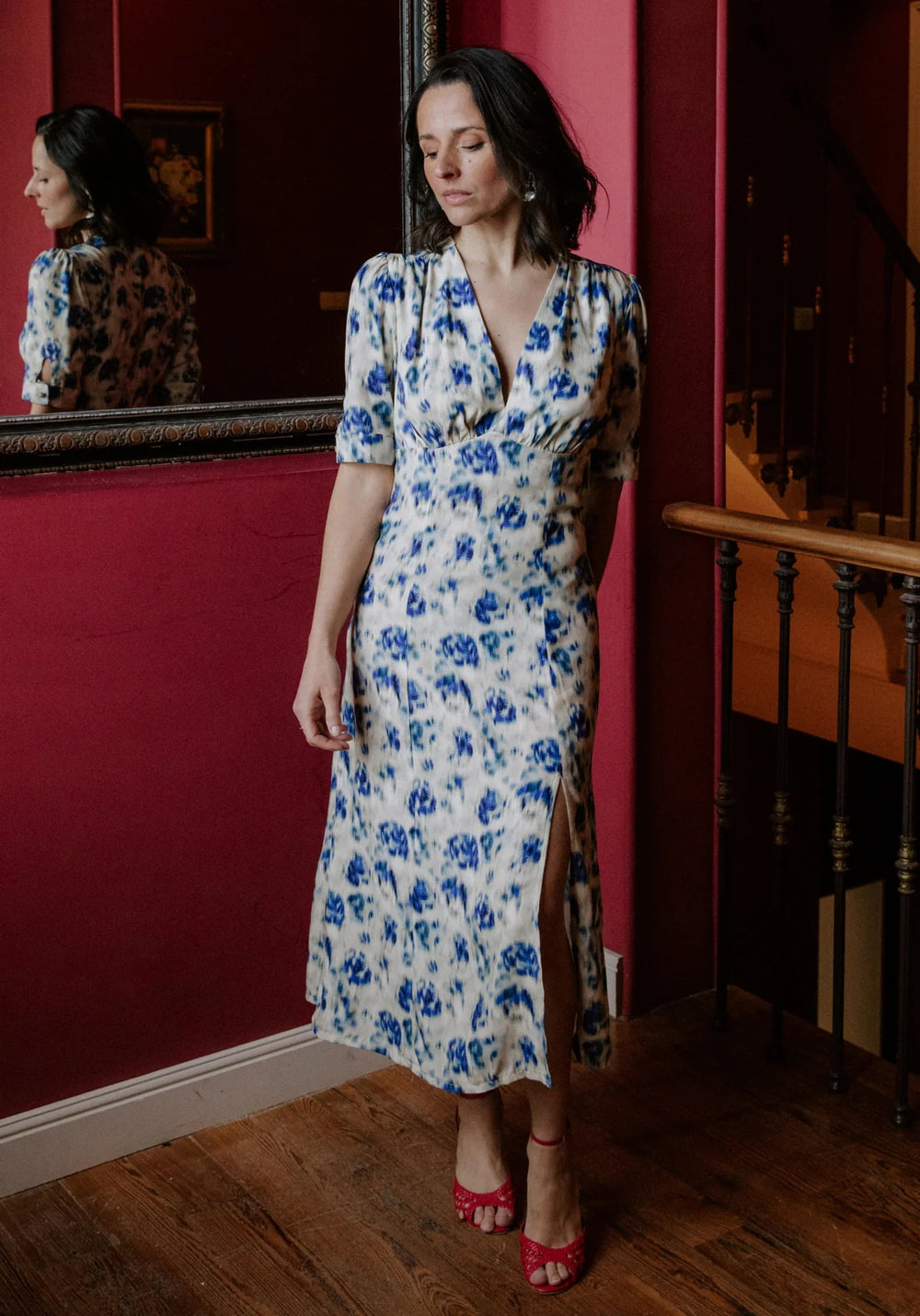 Woman wearing the Rosalie Dress sewing pattern from Maison Fauve on The Fold Line. A dress pattern made in viscose, cotton, linen, silk, poplin, crepe, or satin fabric, featuring a deep V-neckline, fitted bodice with gathers under the bust, mid-length sleeves with a buttoned cuff, a front slit, and midi length.