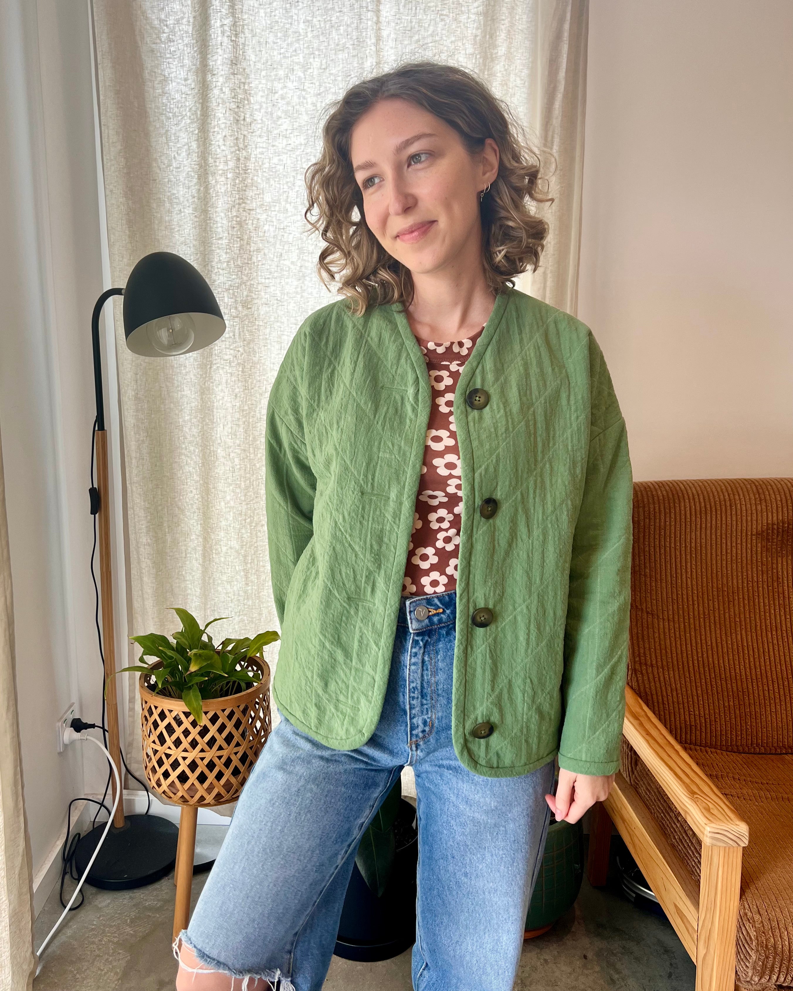 Woman wearing the Sage Jacket sewing pattern from Elle Stitch on The Fold Line. A reversible quilted jacket pattern made in linen, cotton, hemp, or lightweight denim fabric, featuring a boxy fit, drop shoulder, button front, long sleeves, and bias bound edges.