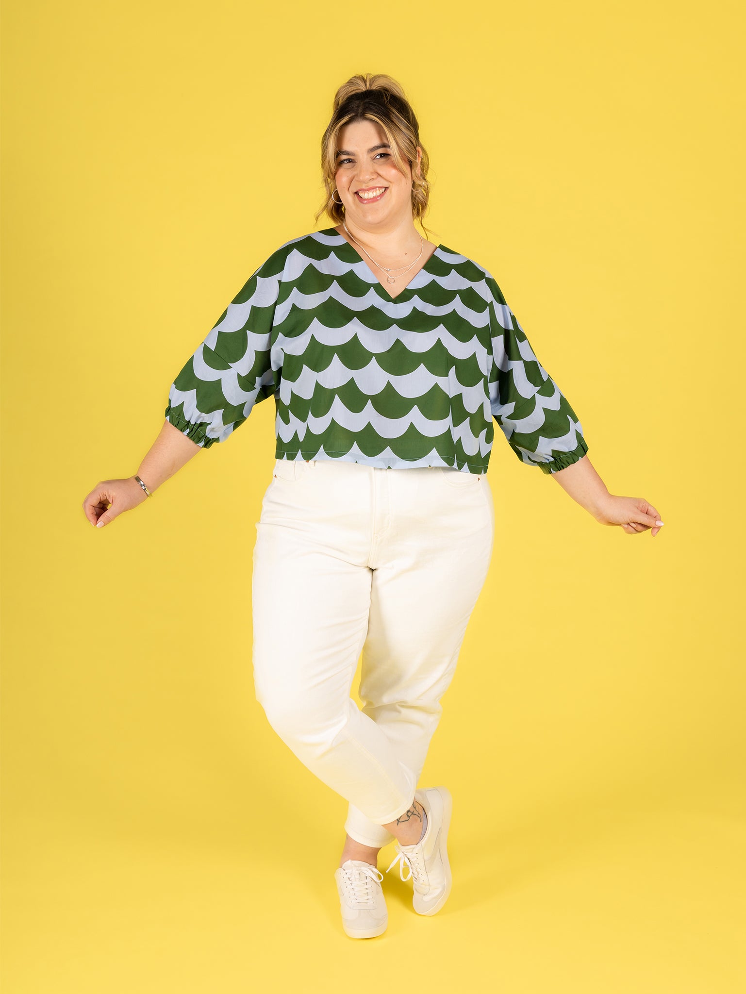 Woman wearing the Samara Top sewing pattern from Tilly and the Buttons on The Fold Line. A top pattern made in cotton lawn, poplin, seersucker, double gauze, washed linen, linen-viscose blend, viscose (rayon), lyocell (tencel), or crepe de chine fabric, featuring a relaxed fit, drop shoulders, V-neckline, mid length sleeves, and cropped length.