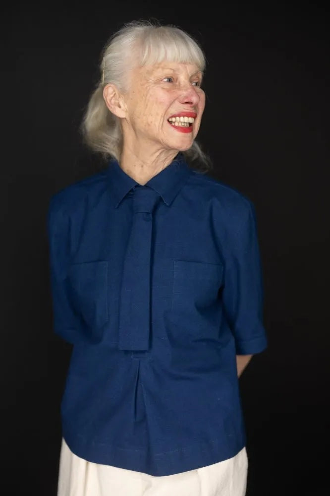 Woman wearing the Scout Shirt sewing pattern from Merchant & Mills on The Fold Line. A shirt pattern made in linen, lightweight denim, cotton chambray, poplin, or linen/cotton blend fabric, featuring a collar, popover button placket, mid-length sleeves, pockets, and an optional tie.