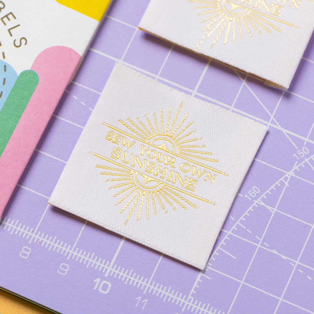 The 'Sew Your Own Sunshine' woven labels from Little Rosy Cheeks on The Fold Line. The pack includes 4 labels ready to be sewn into your handmade clothes.