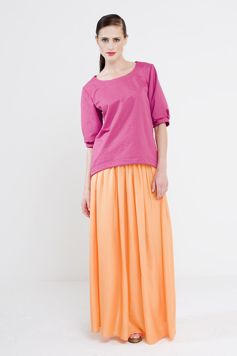 Woman wearing the Sophie Blouse sewing pattern from Schnittchen Patterns on The Fold Line. A blouse pattern made in cotton, linen, denim, or silk fabric, featuring a round neckline and slightly puffed elbow-length sleeves.