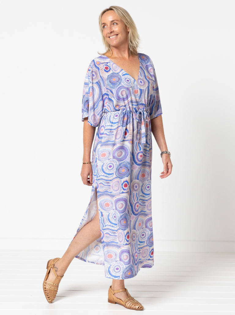 Woman wearing the Summer Coverup sewing pattern from Style Arc on The Fold Line. A caftan style dress pattern made in silk, rayon, or any soft woven fabric, featuring a V-neck, extended shoulder line, wide floaty sleeves, a drawstring under the bust, and maxi length with side splits.