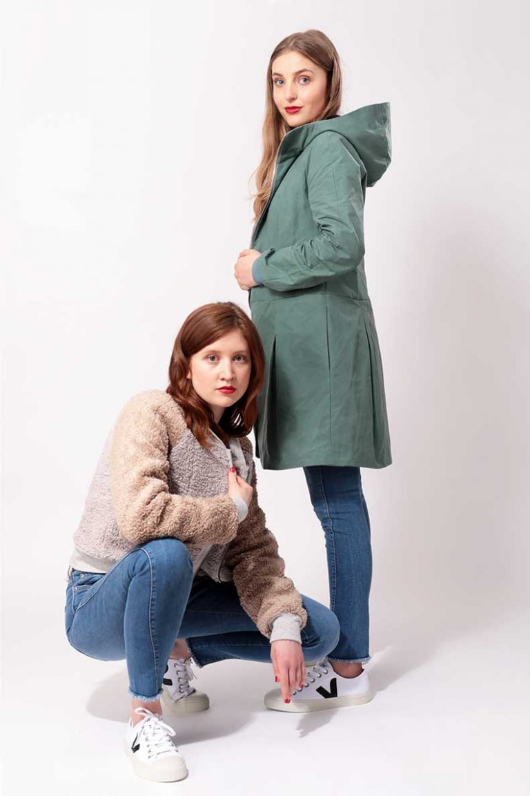 Women wearing the Tilda Jacket and Short Coat sewing pattern from Schnittchen Patterns on The Fold Line. A lined bomber jacket and above-knee coat pattern made in plush, wool, denim, quilted, or oilskin fabric, featuring princess seams, raglan sleeves, and a ribbed collar or hood.