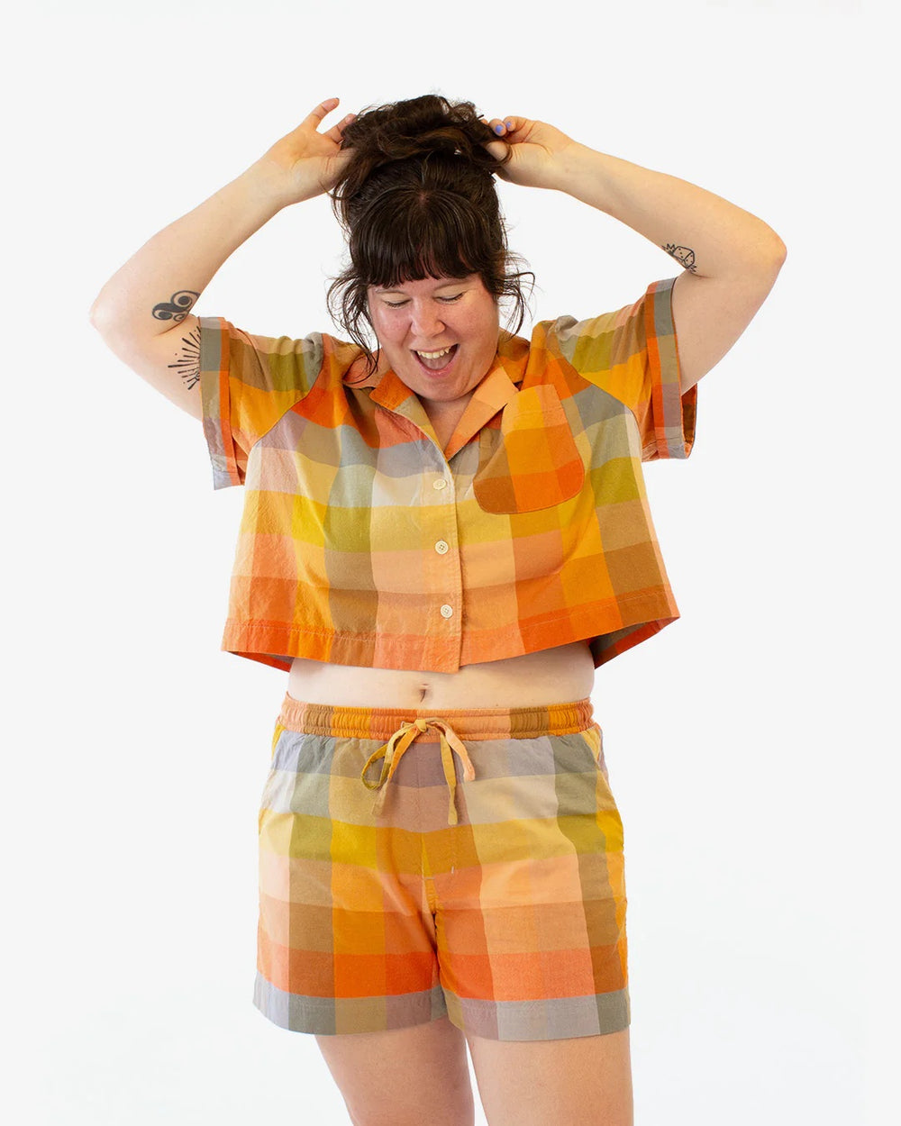 Woman wearing the Ukee Shorts sewing pattern from Helen's Closet on The Fold Line. A shorts pattern made in cotton, linen, lighter weight denim or cotton twill, rayon/viscose challis, or tencel fabric, featuring an elastic waistband with a drawstring, faux fly, slanted front pockets, and back patch pockets.