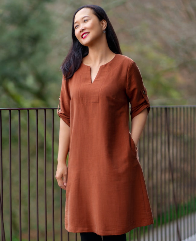 Woman wearing the Vikos Dress sewing pattern from Itch to Stitch on The Fold Line. A dress pattern made in rayon/viscose challis, rayon/viscose twill, chambray, linen, lightweight flannel, or broadcloth fabric, featuring a relaxed fit, split neckline, three-quarter length sleeves with buttoned tabs, in-seam pockets, and knee length.