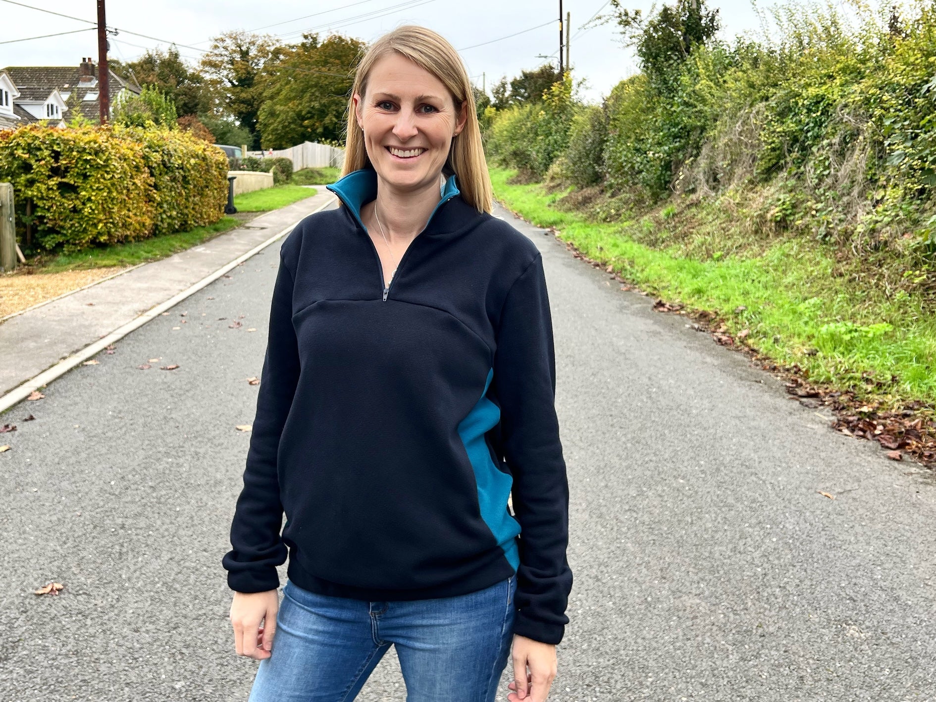 Woman wearing the Women's Quokka Quarter Zip Top sewing pattern from Waves & Wild on The Fold Line. A top pattern made in sweatshirt fleece or alpine fleece fabric, featuring a relaxed fit, high neck with a zip, long sleeves, and pockets.